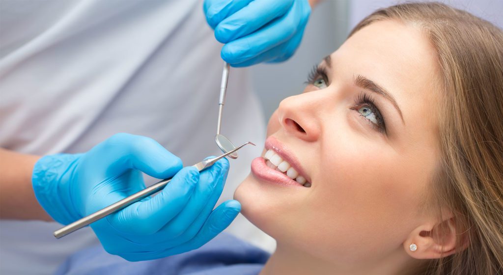 Dentist taking a look a woman's teeth